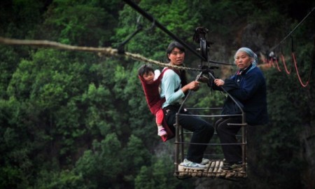 Жителі села Хунде користуються канатною дорогою, щоб перетнути ущелині Ву Мен